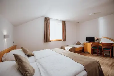 a bedroom with two beds and a desk with a computer at Gostišče Iršič in Slovenska Bistrica