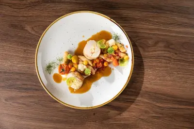 a plate of food with vegetables and gravy on a table at Gostišče Iršič in Slovenska Bistrica