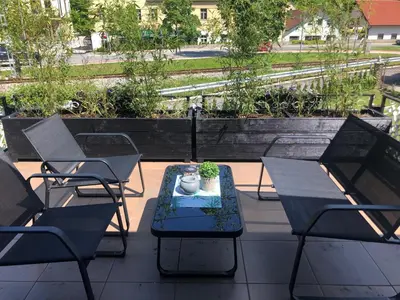 a patio with chairs and a table with a vase on it at Apartma center in Rogaška Slatina