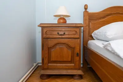 a wooden nightstand with a lamp on it next to a bed at Winery Toplak in Juršinci