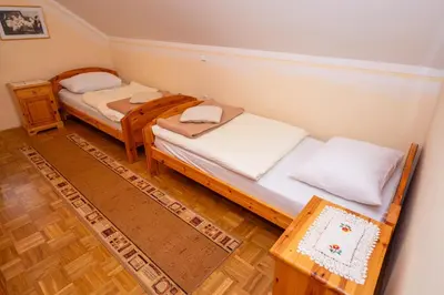 two twin beds in a room with wooden floors at Winery Toplak in Juršinci