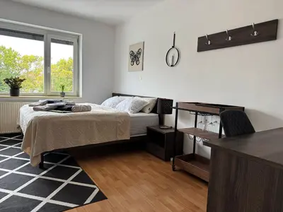 a bedroom with a bed and a desk and a window at RailwayRooms22 in Ljubljana