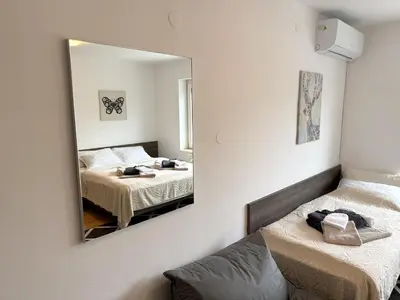 a bedroom with two beds and a mirror at RailwayRooms22 in Ljubljana