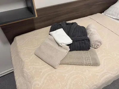 a pile of clothes and towels on a bed at RailwayRooms22 in Ljubljana