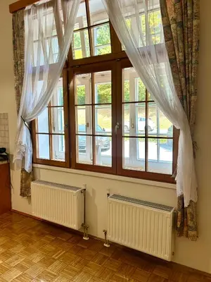 a room with two windows and two radiatoracs at Ana Marija Apartment - Vila Golf in Rogaška Slatina