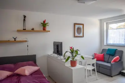 a bedroom with a bed and a couch and a chair at Apartment River Ljubljanica in Ljubljana