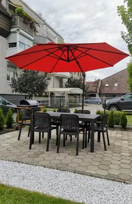 a table and chairs with a red umbrella at Modern appartement with big terrace in Ljubljana in Ljubljana