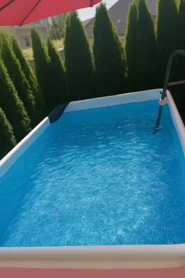 a swimming pool with an umbrella and some bushes at Modern appartement with big terrace in Ljubljana in Ljubljana