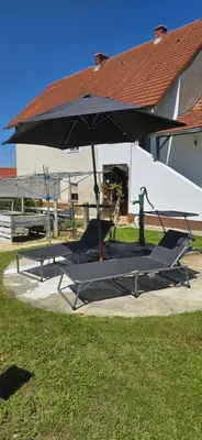 a picnic table and an umbrella in front of a building at Kajžarka in Miklavž pri Ormožu