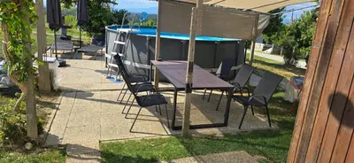 a table and chairs next to a swimming pool at Kajžarka in Miklavž pri Ormožu