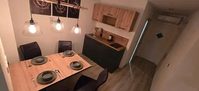 a kitchen with a wooden table with chairs and lights at Kajžarka in Miklavž pri Ormožu