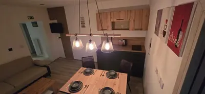 a small kitchen with a wooden table and lights at Kajžarka in Miklavž pri Ormožu