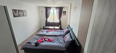 a small bedroom with a bed and a chair at Kajžarka in Miklavž pri Ormožu