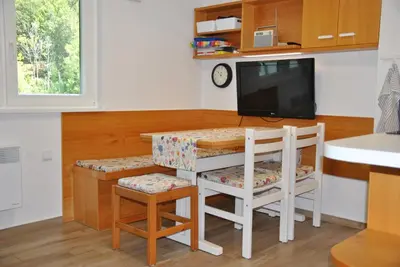 a kitchen with a table and two chairs and a television at Studio Korra in Kranjska Gora