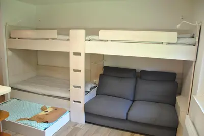 a bunk bed with a couch in a room at Studio Korra in Kranjska Gora