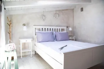 a bedroom with a white bed with purple pillows at Lavandula House in Štanjel