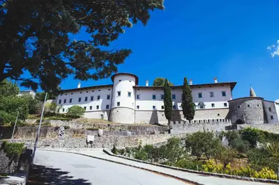 a castle on a hill with a road in front at Lavandula House in Štanjel