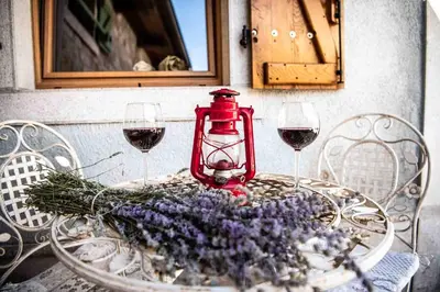 a table with two glasses of wine and a red lantern at Lavandula House in Štanjel