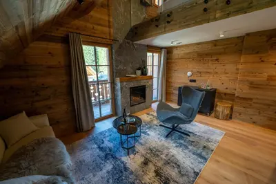 a living room with a couch and a chair and a fireplace at Jakobs Lodge in Zgornje Gorje
