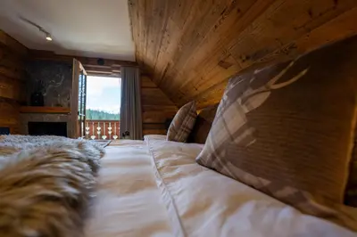 a bedroom with a large bed with a wooden ceiling at Jakobs Lodge in Zgornje Gorje