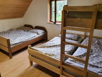 a bedroom with two bunk beds and a window at planinski dom Goška Ravan in Kamna Gorica