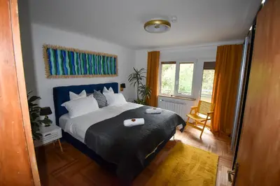 a bedroom with a large bed with a blue headboard at Apartma Karakter in Maribor