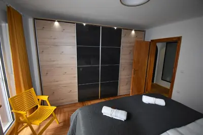 a bedroom with a bed and a yellow chair at Apartma Karakter in Maribor