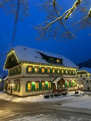 a hotel in the snow at night at Pod Gora Boutique Hotel in Kranjska Gora