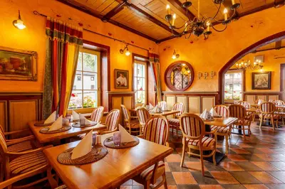 a restaurant with wooden tables and chairs in a room at Pod Gora Boutique Hotel in Kranjska Gora