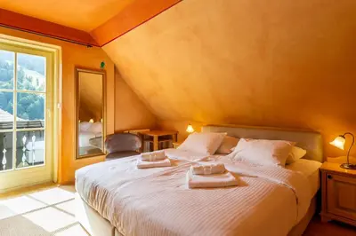 a bedroom with a large bed with two towels on it at Pod Gora Boutique Hotel in Kranjska Gora