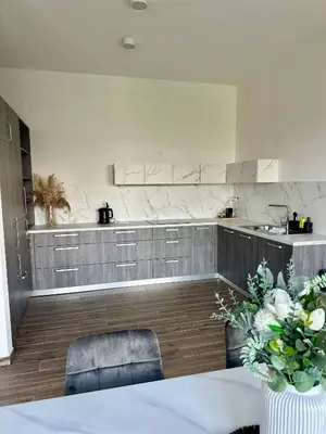 a kitchen with a table and two chairs and a counter at Apartma La Vie in Kostanjevica na Krki