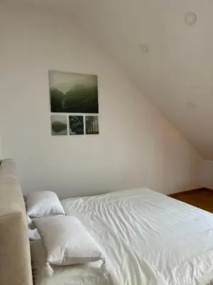a bedroom with a white bed and a picture on the wall at Apartma La Vie in Kostanjevica na Krki