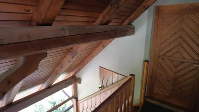 a staircase with wooden railings and a wooden door at Apartment-Koželj in Dobrna