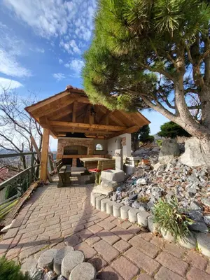 a wooden pavilion with a picnic table and a tree at Apartment-Koželj in Dobrna