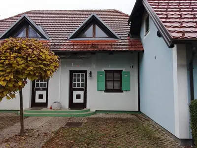 a white house with green doors and a tree at Melisa's Holiday Home in Mostec