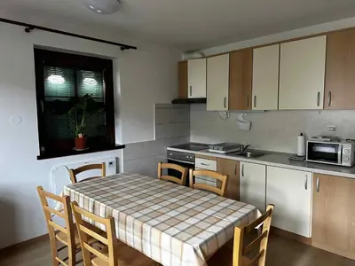 a kitchen with a table and chairs and a kitchen with a table and a table at Melisa's Holiday Home in Mostec