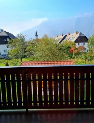 a wooden bench with a view of a town at Apartment Veduta in Bovec