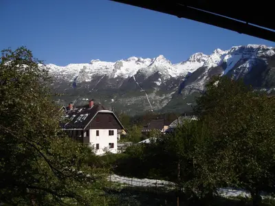 a house in front of a snow covered mountain at Apartment Veduta in Bovec
