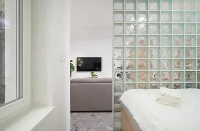 a bedroom with a couch and a tv in a room at Petka apartments in Ljubljana