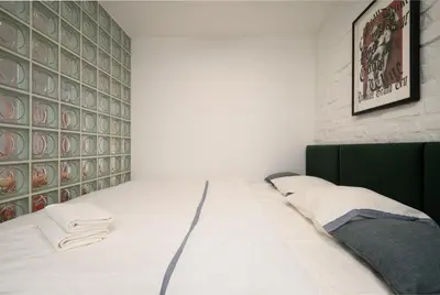 a white room with a bed and a brick wall at Petka apartments in Ljubljana