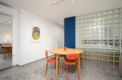 a dining room with a table and chairs and a wall of wine bottles at Petka apartments in Ljubljana