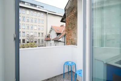a blue stool sitting on a balcony with a window at Petka apartments in Ljubljana