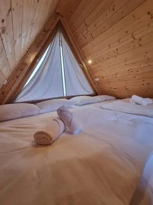 a bed in a room with a large window at Glamp Pr Kuzuc in Cerklje na Gorenjskem