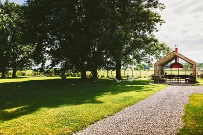 a park with a gazebo and trees and grass at BIG BERRY Kolpa - MIR mobile house in Gradac