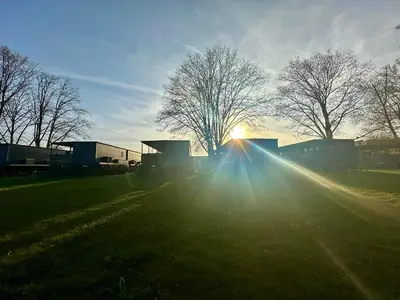 a sun setting in a field with trees and grass at BIG BERRY Kolpa - MIR mobile house in Gradac