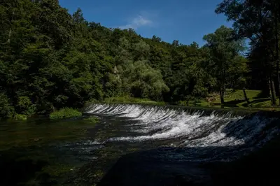 a waterfall on a river with trees in the background at BIG BERRY Kolpa - MIR mobile house in Gradac