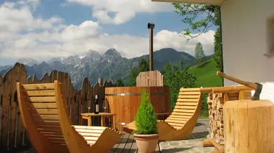 a patio with chairs and a fence with mountains in the background at Holiday chalet 