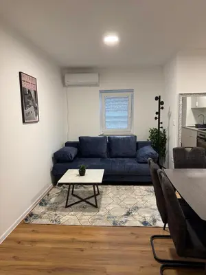 a living room with a blue couch and a table at Apartmaji MAS 1 in Ljubljana