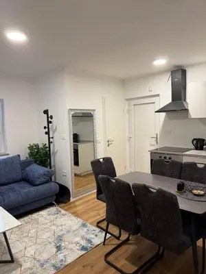 a living room with a table and a blue couch at Apartmaji MAS 1 in Ljubljana