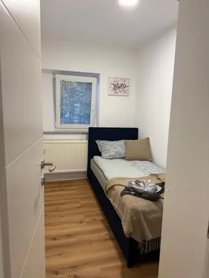a small bedroom with a bed and a window at Apartmaji MAS 1 in Ljubljana